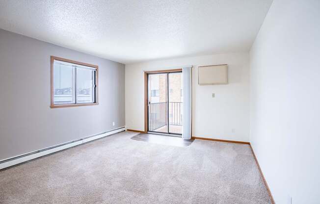 A room with a carpeted floor and a sliding glass door. Fargo, ND Westwood Estates