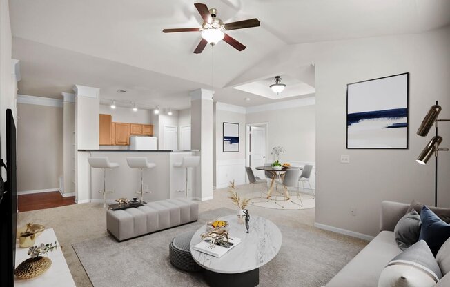 an open living room with a kitchen and a ceiling fan