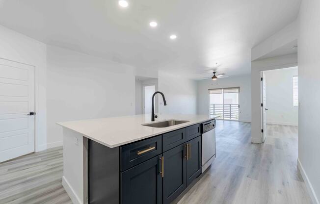 a white and black kitchen with a large counter top and a sink