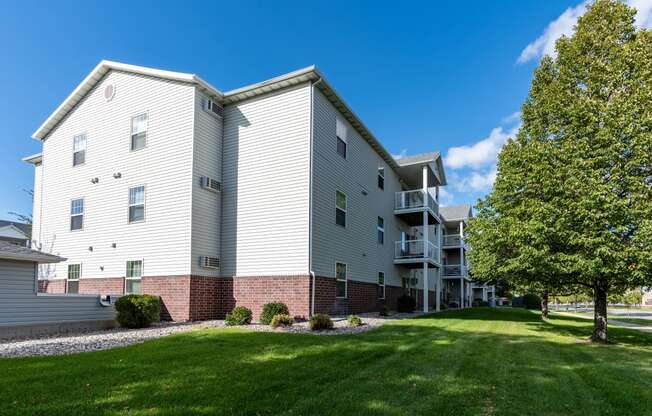 An exterior of an apartment with a grassy area out front.