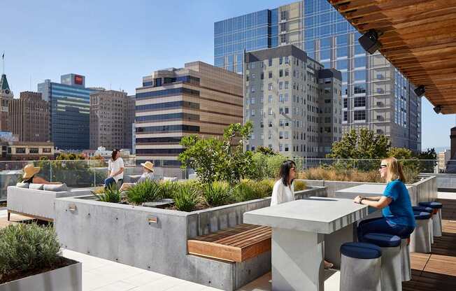 Two women are sitting at a table on a rooftop patio.