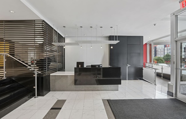 A black and white reception area with a black counter and a black and white rug.