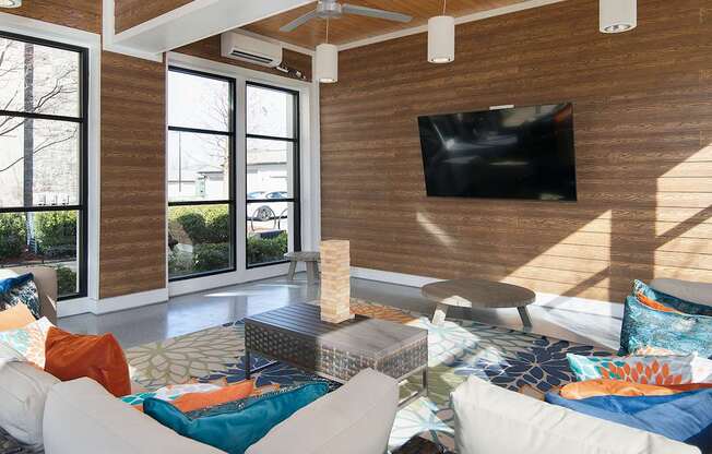 outdoor lounge with a white couch and a flat screen TV mounted on the wall.