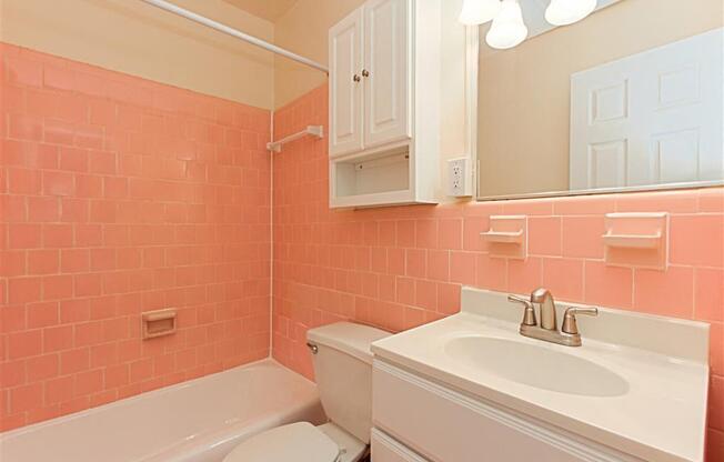 bathroom with sink, mirror, tub, toilet, medicine cabinet and tile detail at chillum place apartments in lamond riggs washington dc