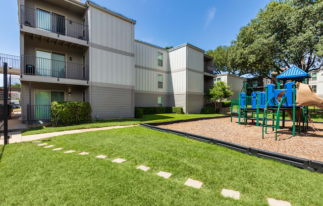 A grassy area next to the playground at The Biltmore Apartments located in the Vickery Midtown neighborhood of Dallas, TX.