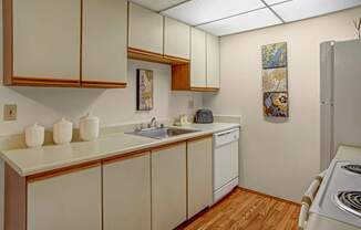 A kitchen with wooden cabinets and a white counter top.