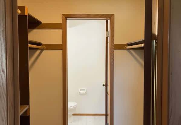 A bathroom with a toilet and sink is visible through an open door.