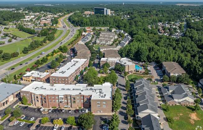 An aerial view of a school with a parking lot in front.