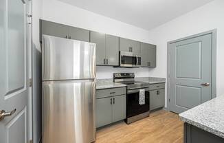 a kitchen with stainless steel appliances and gray cabinets