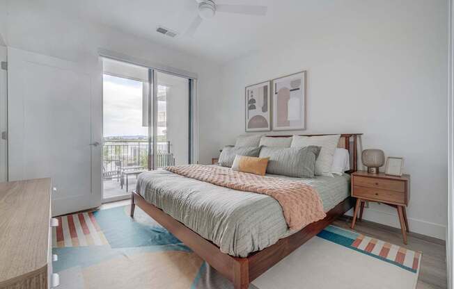 A bedroom with a bed, nightstand, and a ceiling fan.