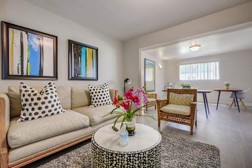 A living room with a couch, chairs, and a coffee table.