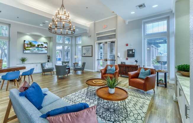 A living room with a grey couch and a chandelier.