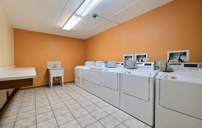 a row of washers and dryers in a laundry room at France, Fargo North Dakota