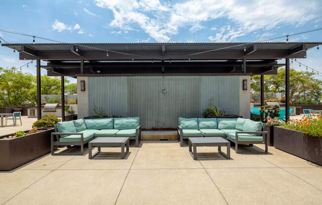 A patio area with a metal building and two green couches.
