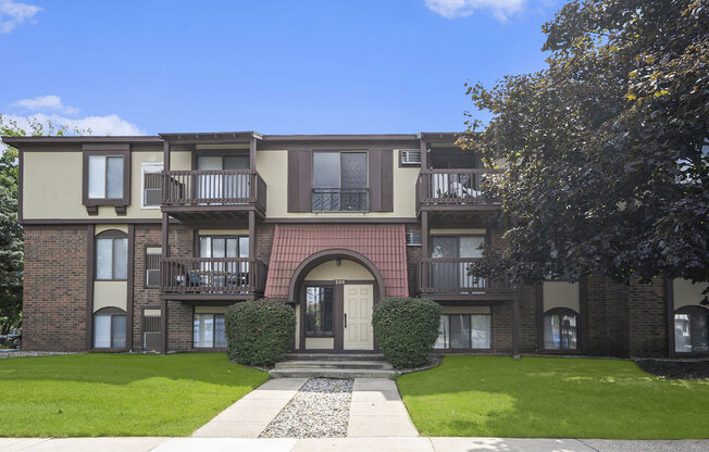 front view of building with green grass and trees at Apple Ridge Apartments, Michigan, 49534