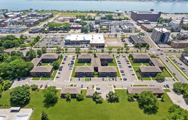 an aerial view of a parking lot with buildings in the background and a body of water in at Lafayette Park Place, Detroit, MI, Detroit, Michigan