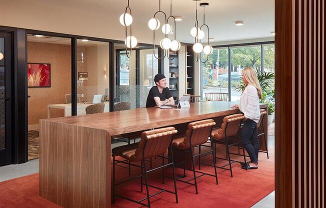 a couple of people standing in front of a wooden table