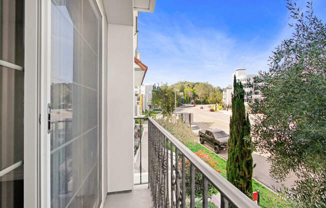 a balcony with a view of a street and a building with a glass door