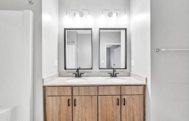 a bathroom with two mirrors and two sinks