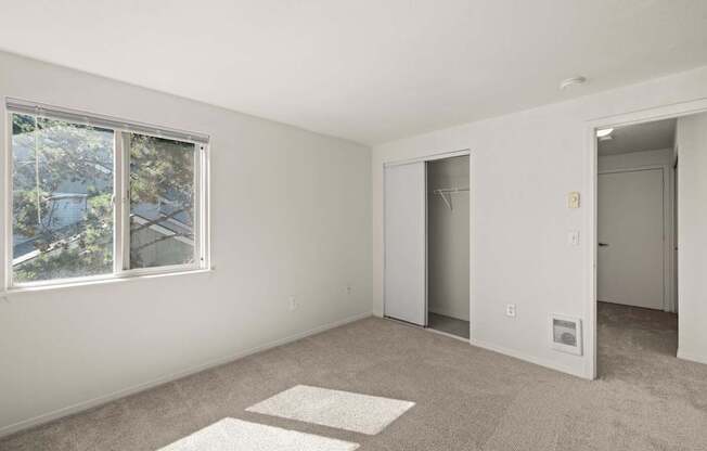 A room with a window, a door, and carpeted floor at Clackamas Trails Apartments, Oregon, 97222