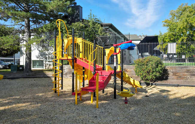 A playground with a yellow and red slide.