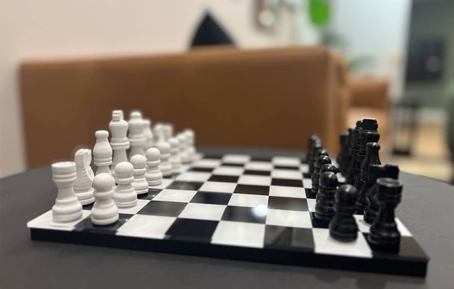 A chessboard with a black pawn and white pawn in the middle of the game.