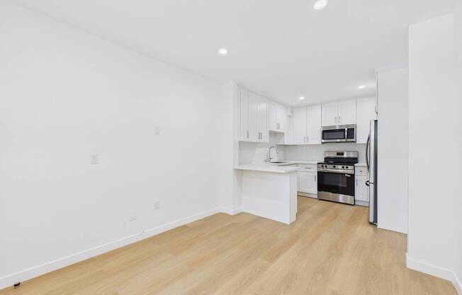 A kitchen with white cabinets and a microwave.
