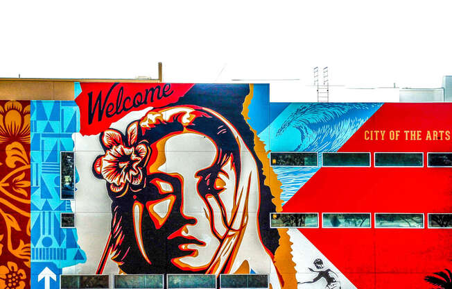 A mural on a wall welcomes people to the City of the Arts.