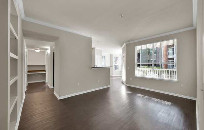 a bedroom with hardwood flooring and a large window