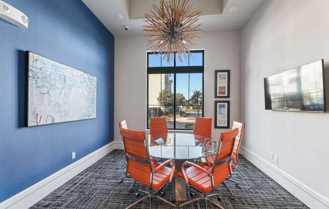 a dining room with a glass table and chairs and a large window