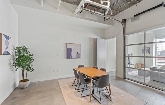 A room with a table and chairs and a plant.