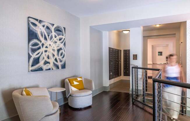 A modern room with a large abstract painting on the wall and a person walking in the background.