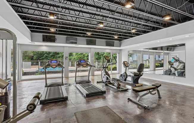 A gym with treadmills, exercise bikes, and other equipment.