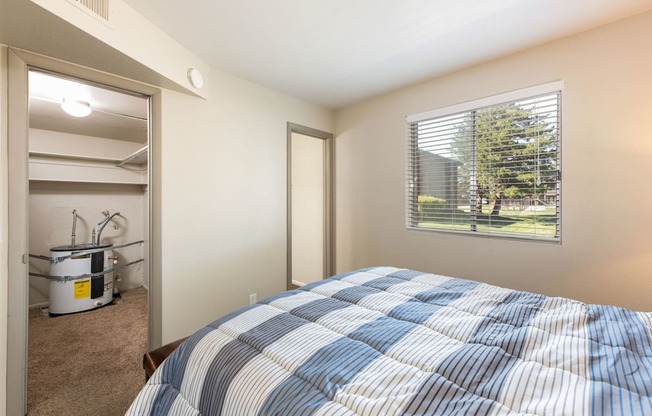 a bedroom with a bed and a closet with a window