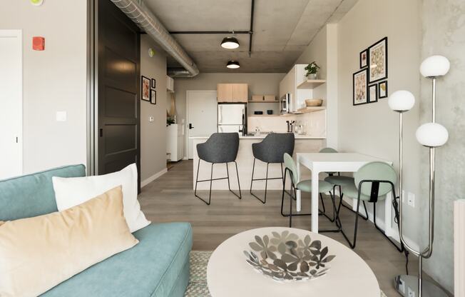 a living room and dining room with a couch and a table at One Foundry Way, St. Louis, 63110