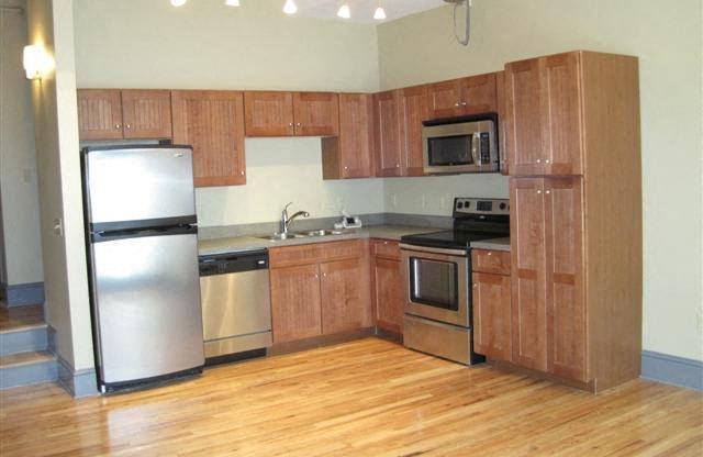 a kitchen with wooden cabinets and stainless steel appliances