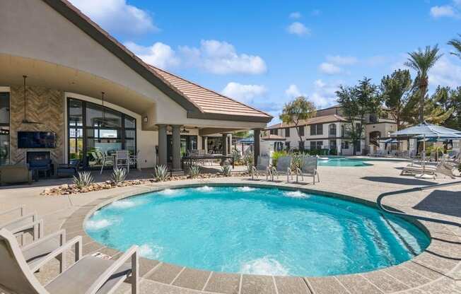 a pool with chairs and umbrellas in front of a building