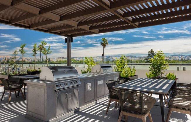 a patio with two grills and a table with chairs