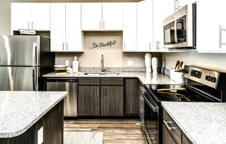 Two tone cabinet kitchens with extra storage and stainless steel appliances at AXIS apartments in Papillion, NE