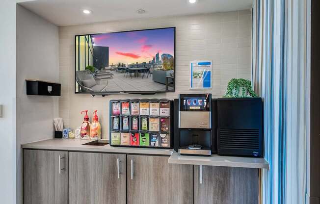 A modern kitchen with a large TV screen showing a sunset scene.