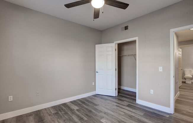a bedroom with hardwood floors and a ceiling fan