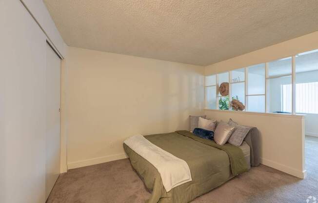 A bedroom with a bed and a carpeted floor.