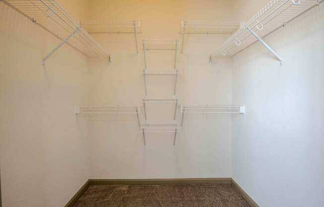 a walk in closet with white walls and shelves at Parc at Bentonville Apartments in Bentonville, AR