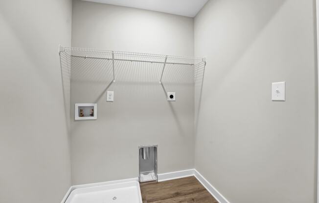 a white bathroom with a tub and a shelf on the wall