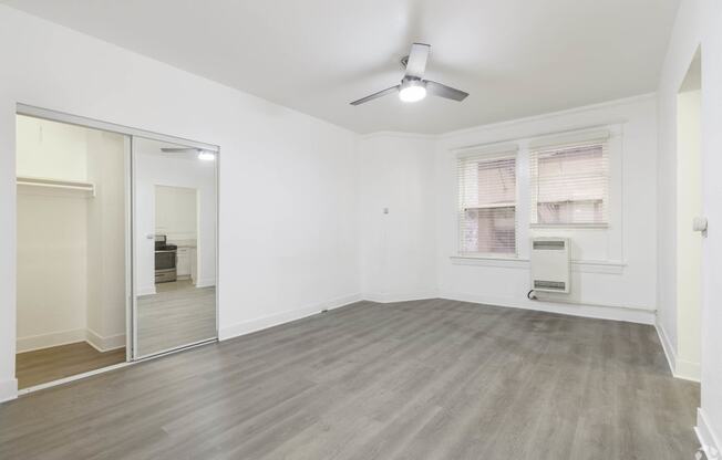an empty living room with a mirrored closet and a ceiling fan at Clay & Tiffany, Portland, 97201
