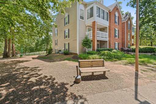 A bench sits in front of a building with a brick chimney.