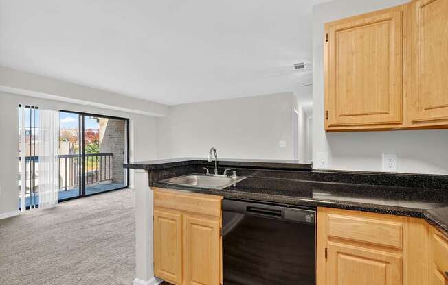 A kitchen with wooden cabinets and a black countertop.