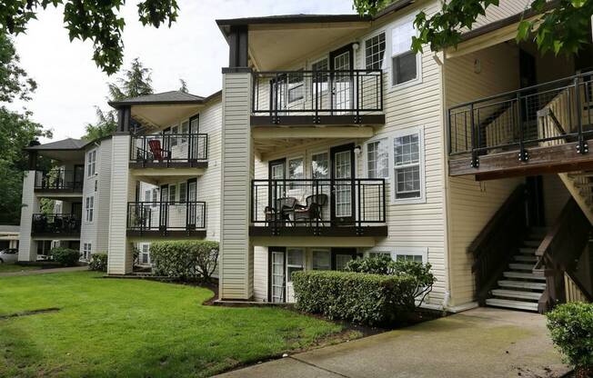 an apartment building with balconies and a grass yard