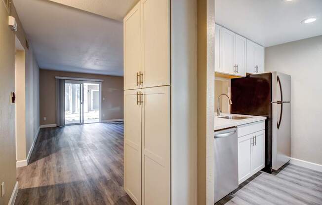 A kitchen with white cabinets and a refrigerator.
