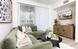 a living room with green couches and a coffee table